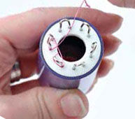 Wire being wrapped around the spokes of the knitter